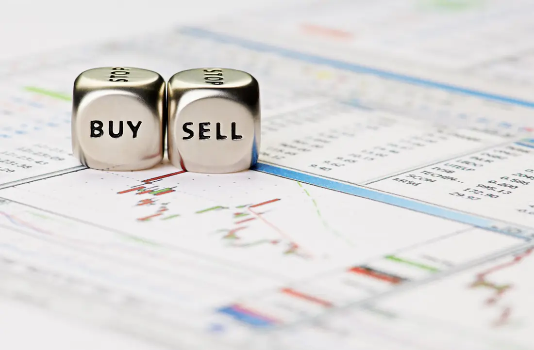 Dice marked buy and sell on business papers