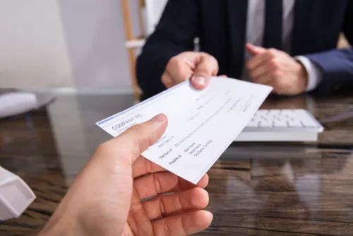 Cheque being handed across a desk