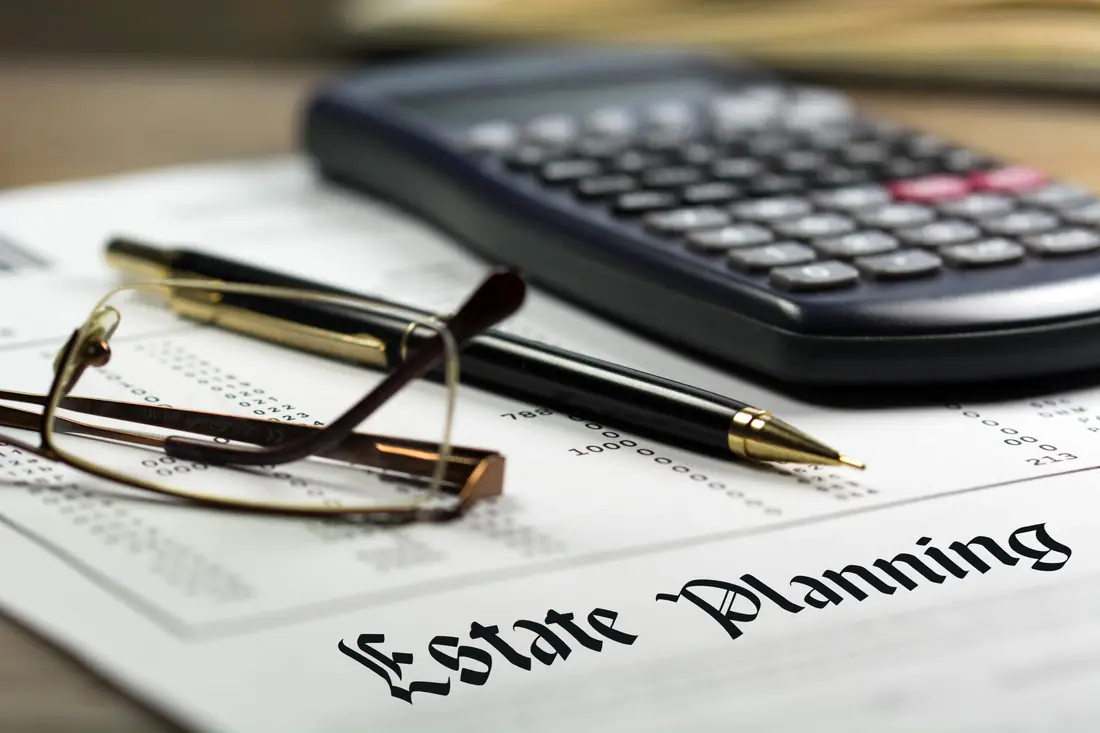 Estate planning papers with glasses, a pen and a calculator