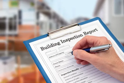Building inspection report on a clipboard being filled in
