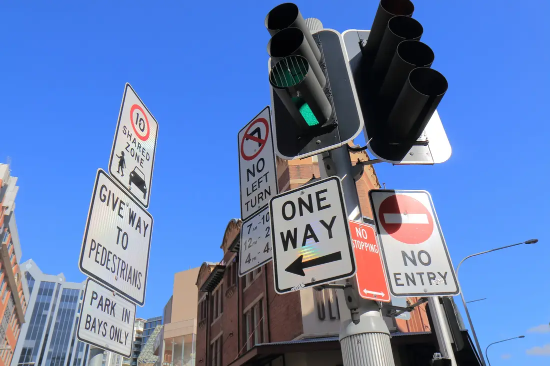 Sydney street signs and traffic lights under a blue sky