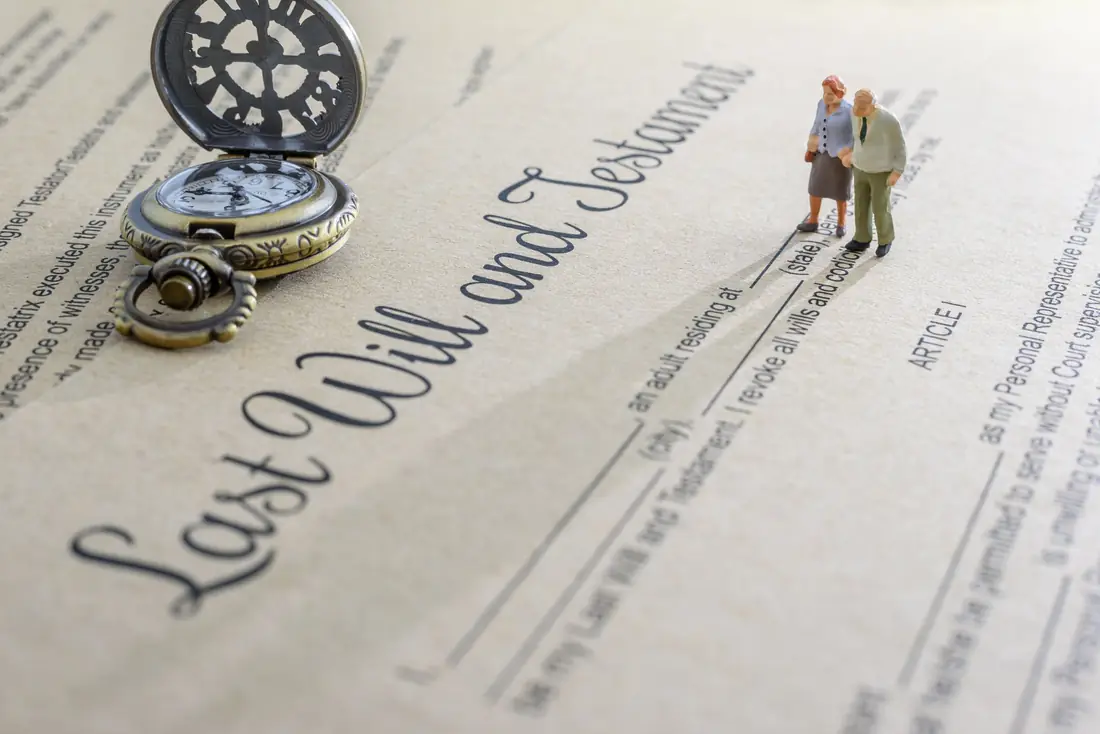 A will document with an older couple and a pocket watch